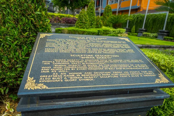 Informační znak na černé cementu kamenná socha Boha Višnua v Gunung Kawi, Bali, Indonésie — Stock fotografie