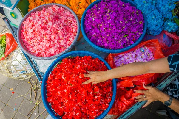 BALI, INDONESIA - MARCH 08, 2017: Outdoor Bali flower market. Flowers are used daily by Balinese Hindus as symbolic offerings at temples, inside of colorful baskets — Stock Photo, Image
