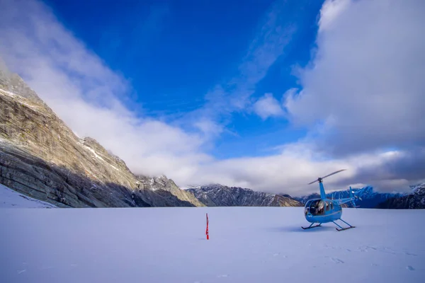 ILHA DO SUL, NOVA ZELÂNDIA - 24 DE MAIO DE 2017: Helicóptero e piloto esperando sobre a neve por caçadores em South Westlands Southern Alps, Nova Zelândia — Fotografia de Stock