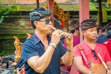 Bali, Endonezya - 05 Nisan 2017: bazı müzik aleti çalma kimliği belirsiz adam Flüt ve Bali Ubud tmple içinde karanlık sunglases giyen bulunan Endonezya