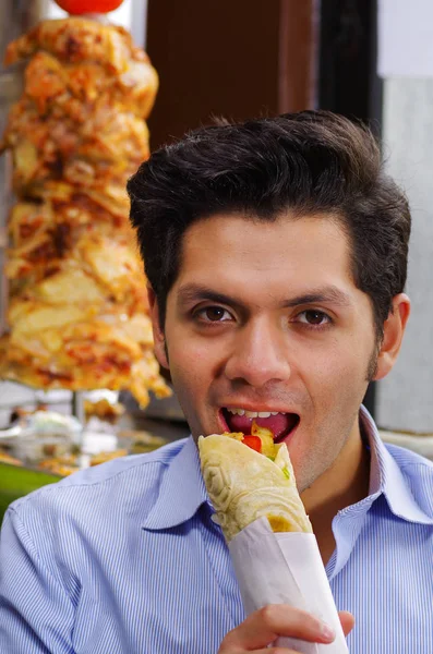 Yakışıklı adam ile tavuk ve kuzu eti lezzetli bir shawarma yeme — Stok fotoğraf