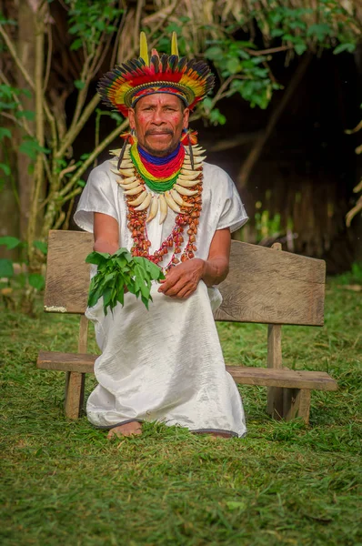 Lago agrio, ecuador - 17. November 2016: siona schamane in traditioneller kleidung mit federhut in einem indigenen dorf im cuyabeno wildlife reservat — Stockfoto