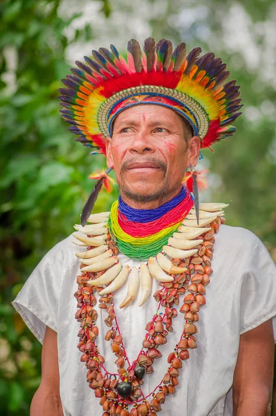 Lago Agrio, Ecuador - 17 November 2016: Närbild av en Siona shaman i traditionell dräkt med en fjäder hatt i en inhemsk by i Cuyabeno Wildlife Reserve — Stockfoto