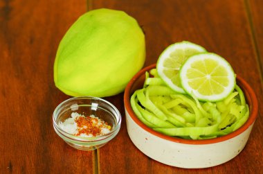 Dilimlenmiş mango ile tuz bir tabakta servis