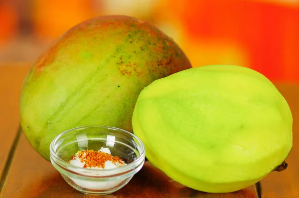 Ham ve soyulmuş mango arkasında bir tuz ve biber toz kase — Stok fotoğraf