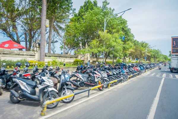 Bali - Indonézia március 08 2017: Egy ismeretlen férfi, ügyelve a motoros magánszálloda parkolt. Legians terület. Legian a külvárosi és a strandot, a nyugati partján Bali — Stock Fotó