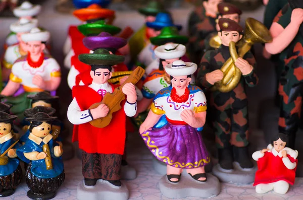 QUITO, ECUADOR - 07 MAYO 2017: Hermosas pequeñas figuras de gente andina hechas de barro sobre una mesa blanca — Foto de Stock