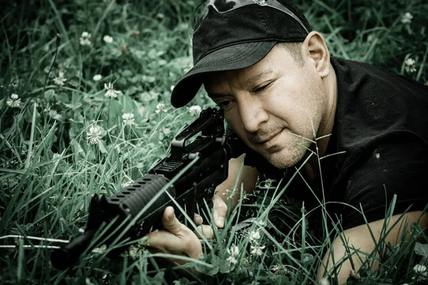 L'homme tenant un fusil k44 et tirant dans l'après-midi, à une cible couchée sur l'herbe verte, petite profondeur — Photo