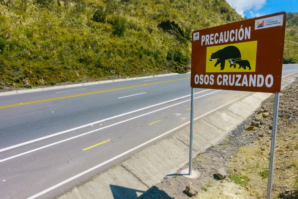 Κίτο, Εκουαδόρ - 07 Μαΐου, 2014: Ενημερωτική πινακίδα να γνωρίζει η διέλευση των αρκούδων στην Παπαγιάκτα, σε ένα όμορφο τοπίο των βουνών σε μια ηλιόλουστη ημέρα με τον δρόμο στο Κίτο του Ισημερινού — Φωτογραφία Αρχείου