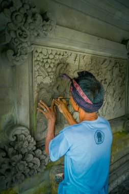 Bali, Endonezya - 08 Şubat 2017: bir duvar çimento, Denpasar Bali sanat yapmak için bir keski kullanarak adam Endonezya'da bulunan