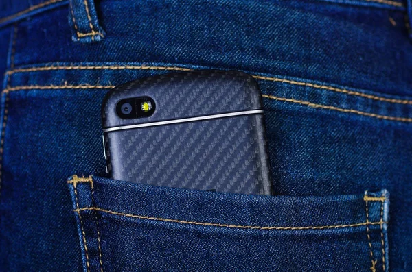 Teléfono celular negro dentro del bolsillo trasero de los jeans —  Fotos de Stock