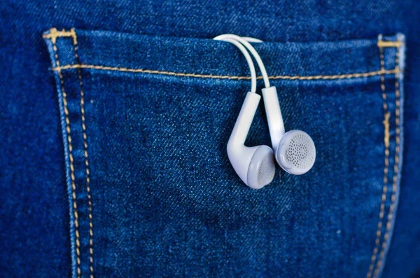 Fones de ouvido brancos dentro do bolso traseiro de jeans — Fotografia de Stock