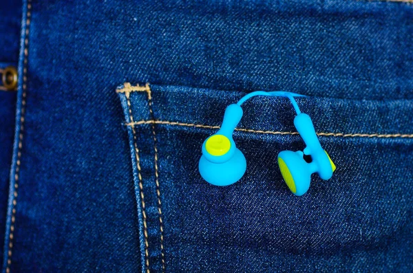 Fones de ouvido brancos dentro do bolso traseiro de jeans — Fotografia de Stock
