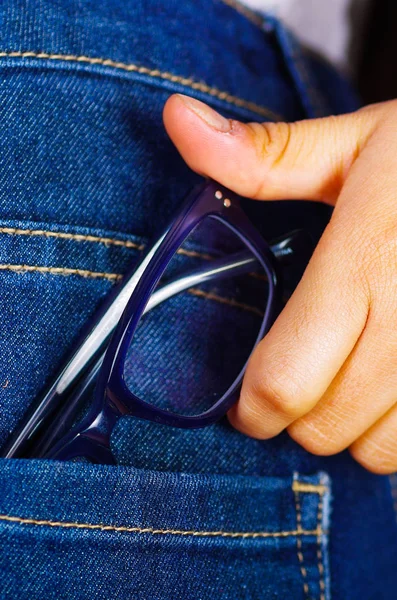 Γυναίκα χέρι που κρατά μια γυαλιά στο εσωτερικό του τζιν πίσω τσέπη — Φωτογραφία Αρχείου
