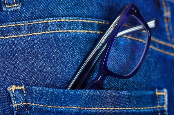 Розовые очки в заднем кармане джинсов — стоковое фото