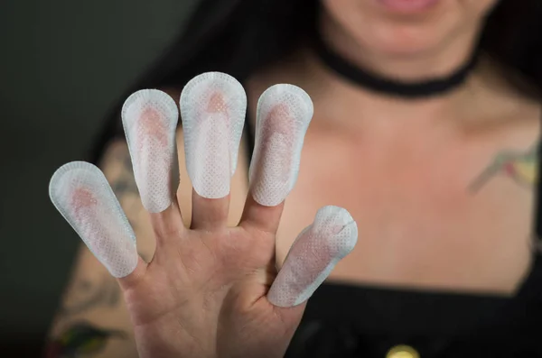 Close up of young woman wearing nails protector in her nails, hand and ideal clean manicure, in a black background — Stock Photo, Image