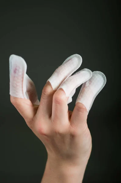 Close up of young woman wearing nails protector in her nails, hand and ideal clean manicure, in a black background — Stock Photo, Image