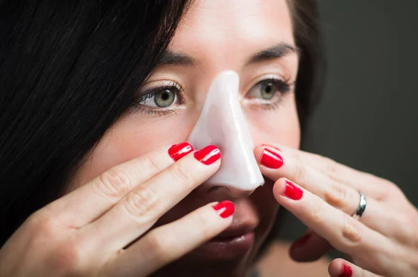 Närbild på en vacker ung kvinna aplying en vit näsa mask rengör huden — Stockfoto