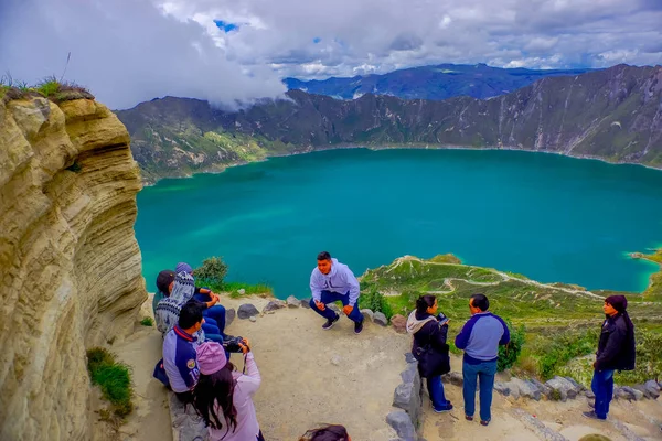 QUITO, ECUADOR - NOVEMBER, 25 2016: Unidentified people taking pictures and enjoying the view of lake with a beautiful magenta color of the Quilotoa caldera. Quilotoa is the western volcano in Andes — Stock Photo, Image