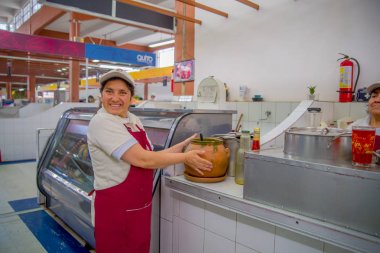 Quito, Ekvator - 23 Kasım 2016: belirsiz gülümseyen kadın Belediye piyasada Quito şehir San Francisco'da bulunan toprak kap eliyle tutarak