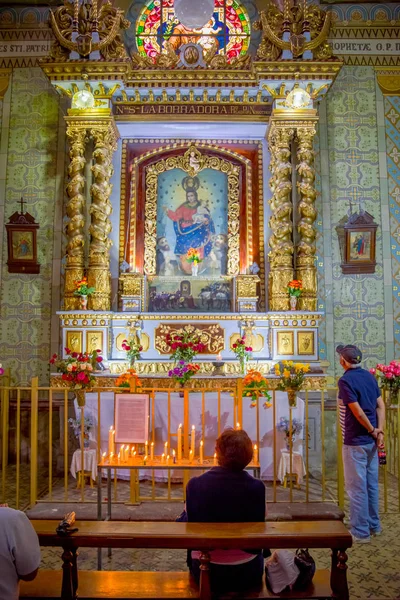 Quito, Ekvádor - 23. listopadu 2016: Neznámých lidí modlí uvnitř kostela a kláštera svatého Františka, se židlemi duchovní obrazy — Stock fotografie