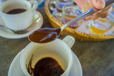 El bir kaşıkla bir Kopi Luwak kahve Bali, Endonezya, çiftliğinde ahşap arka plan ekleme