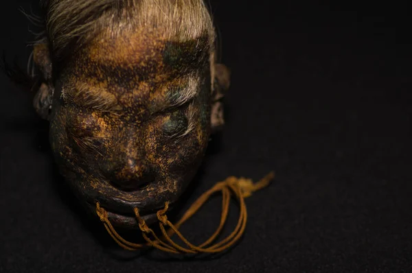 Ett mänskligt huvud för shrunked från ecuador över en mörk bakgrund — Stockfoto
