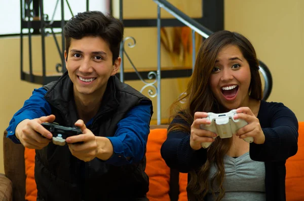 Felice coppia sorridente giocare ai videogiochi sul divano. concetto di home entertainment, videogiochi — Foto Stock