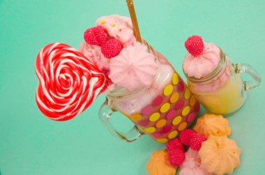 Çilekli süt köpüğü bir plastik hasır üzerinde blackberry şeker ve kalp şeker üstünde tepe, pembe blackberry şekerle ile bir kavanoz içinde bir lezzetli ev yapımı aşırı milkshake, buna yakın bir