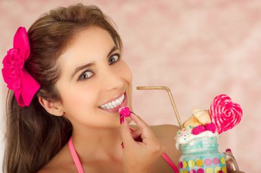 Kapalı onun el hazır blackberry ile oldukça sevimli kadın portresi yemek ve holding ile onu diğer el lezzetli milk shake kavanozda, pembe bir arka plan