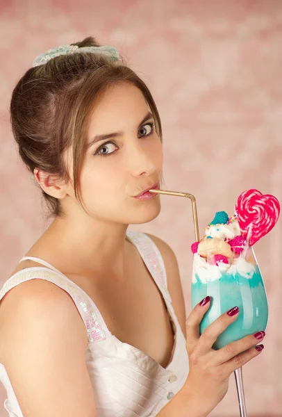 ピンクの背景でおいしいの青いミルク シェークを飲んでかなりかわいい女性のクローズ アップ — ストック写真