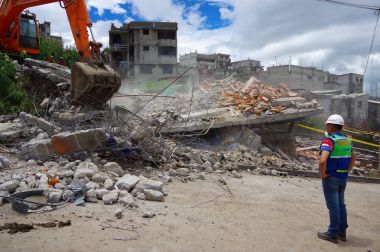 Quito, Ekvator - Nisan, 17, 2016: deprem ve afet, genç bir adamla Quito, Ekvator sürecinde gözlemleyerek temizlik ağır makine tarafından yok evi