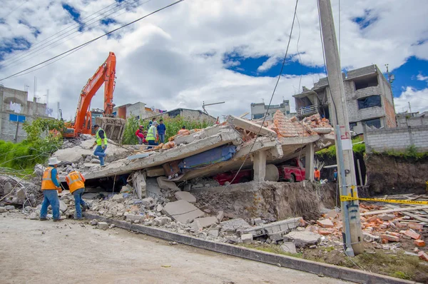 Quito, Ekvator - Nisan, 17, 2016: Tanımlanamayan bir grup insan deprem ve ağır makine Quito, Ekvator içinde felaket Temizleme tarafından yok ev arıyorum