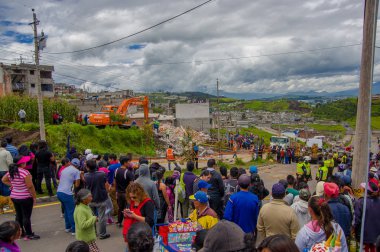 Quito, Ekvator - Nisan, 17, 2016: Deprem ve ağır makine Quito, Ekvator içinde felaket Temizleme tarafından yok ev arayan insanların kalabalık