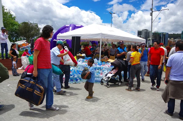 Quito, Ekvator - Nisan, 17, 2016: Afet Yardım gıda, giyim, ilaç ve su kıyılarında deprem kurtulanlar için sağlayan tanımlanamayan vatandaşlar Quito