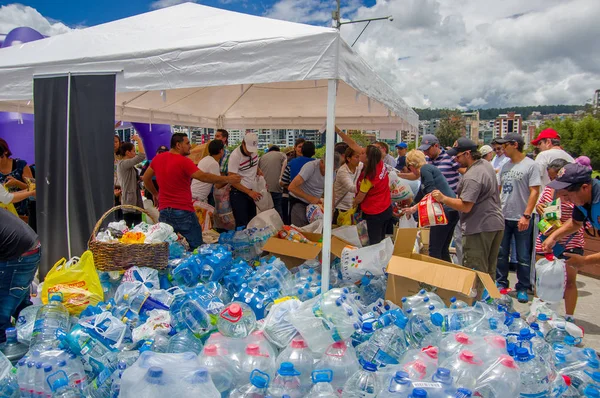 Quito, Ecuador - April, 17, 2016: Unidentified burgers van Quito verstrekken ramp opluchting water voor overlevenden van de aardbeving in de kust — Stockfoto