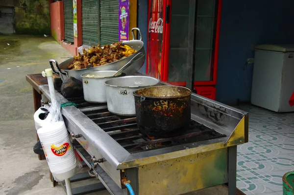 Primer plano de carne de cerdo hornado asado con un maíz, sobre una cocina industrial en local, en una comida típica andina tradicional ecuatoriana sobre una bandeja — Foto de Stock