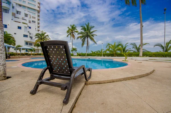 Hermosa piscina con forma de círculo, con una silla de ratán en la frontera en un hotel de lujo en Same, Ecuador — Foto de Stock