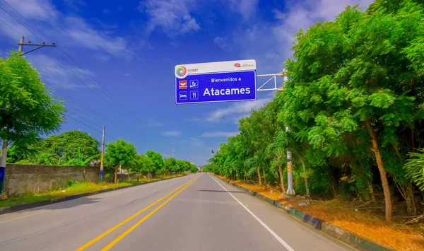 Paved road in the coast, with informative sign, surrounded with abundat vegetation in a sunny day in the Ecuadorian coasts — Stock Photo, Image