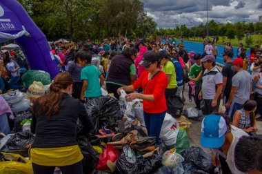 Quito, Ekvator - Nisan, 17, 2016: Deprem ve ağır makine Quito, Ekvator içinde felaket Temizleme tarafından yok ev arayan insanların kalabalık