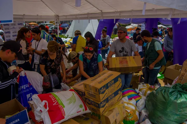 Quito, Ekvator - Nisan, 17, 2016: Deprem ve ağır makine Quito, Ekvator içinde felaket Temizleme tarafından yok ev arayan insanların kalabalık