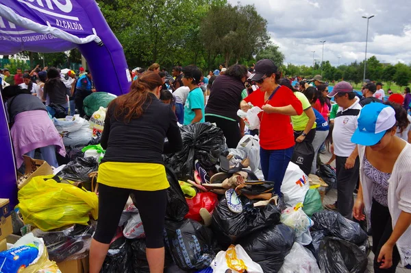 Quito, Ekvator - Nisan, 17, 2016: Deprem ve ağır makine Quito, Ekvator içinde felaket Temizleme tarafından yok ev arayan insanların kalabalık