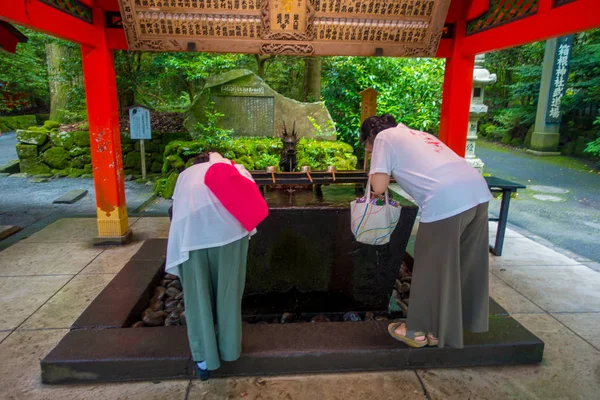 HAKONE, JAPAN - JULY 02, 2017: Unidentified people drinking water at the enter of red Tori Gate at Fushimi Inari Shrine in Kyoto, Japan — Stock Photo, Image