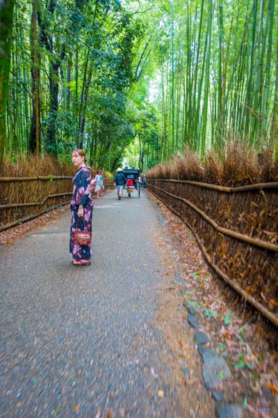 КЁТО, Япония - 05 июля 2017 года: Неопознанная женщина, идущая по тропе в прекрасном бамбуковом лесу в Арашияме, Киото, Япония — стоковое фото