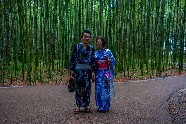 KYOTO, JAPAN - JULY 05, 2017: Pasangan tak dikenal berpose di kamera di sebuah jalan di hutan bambu di Arashiyama, Kyoto, Jepang — Stok Foto