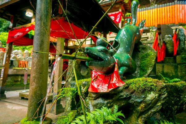 KYOTO, JAPÓN - 05 DE JULIO DE 2017: Un animal de estatua de piedra no identificado con un bambú en la boca en el templo Fushimi Inari Shrine Fushimi Inari Taisha en Japón —  Fotos de Stock