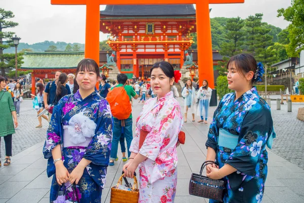 KYOTO, JAPÓN - 05 DE JULIO DE 2017: Mujeres jóvenes visitando un templo inari fushimi en un día lluvioso en Kyoto, Japón — Foto de Stock