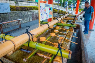 Kyoto, Japonya - 05 Temmuz 2017: Fushimi Inari tapınak Kyoto Pavyonu kimliği belirsiz kişi onların el el yıkama yıkamak