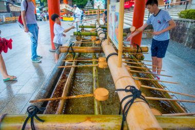 Kyoto, Japonya - 05 Temmuz 2017: Fushimi Inari tapınak Kyoto Pavyonu kimliği belirsiz kişi onların el el yıkama yıkamak