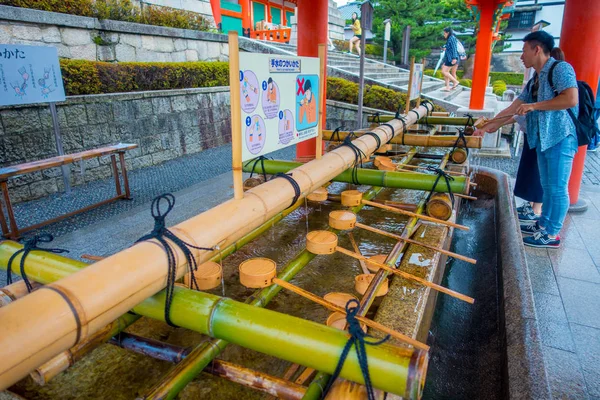 KYOTO, JAPON - 05 JUILLET 2017 : Des personnes non identifiées se lavent les mains au pavillon de lavage des mains du sanctuaire Fushimi Inari à Kyoto — Photo